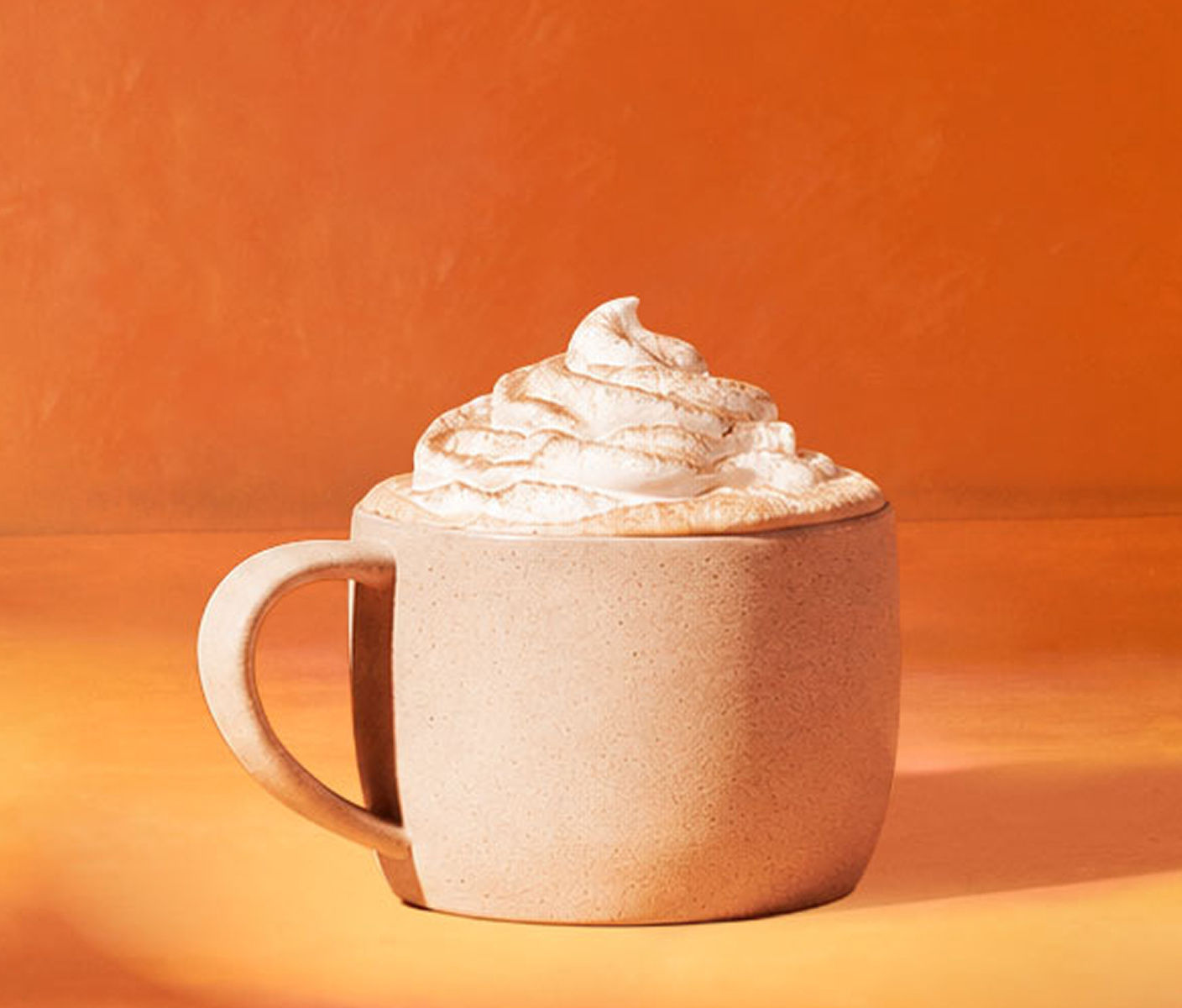 Café frappé garni de crème fouettée et d’épices. 
